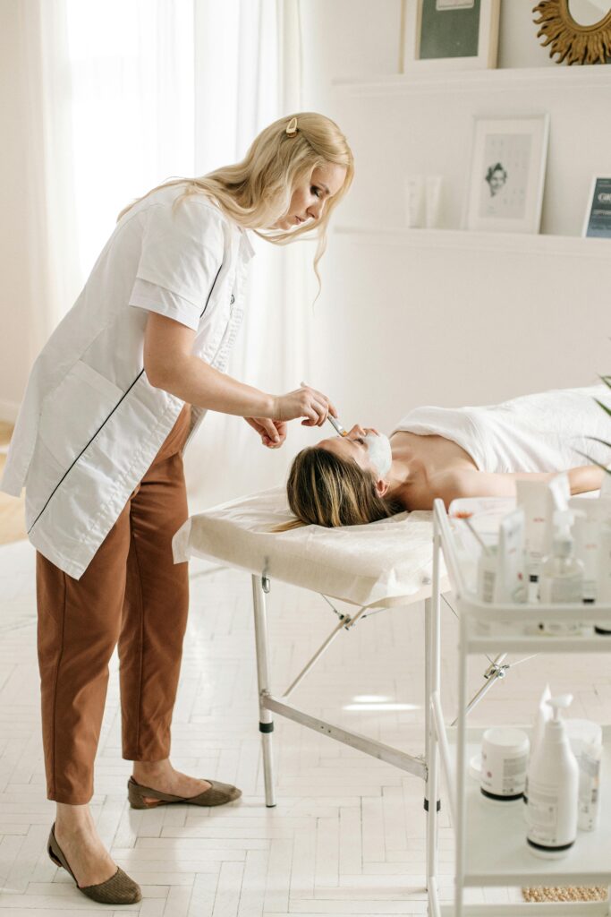 A relaxing facial treatment in a bright, professional spa environment featuring a dermatologist and client.